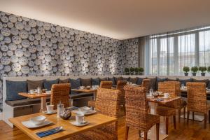 瓦约纳克斯诺威尔酒店酒店的用餐室配有木桌、椅子和投影墙