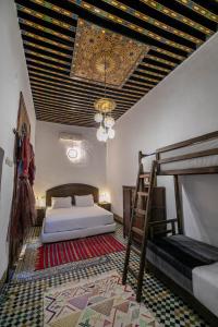 非斯Riad Fes Tala的一间卧室设有两张双层床和吊灯。
