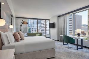 西雅图Hotel 1000, LXR Hotels & Resorts的酒店客房设有一张大床和一张书桌。