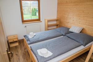 大洛西尼Vilka Viktorka的一间卧室设有两张带蓝色床单的床和窗户。