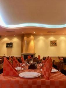 佩什泰拉Daf Trans Hotel的用餐室配有带红色桌布的桌子