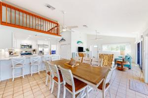基克罗尼海滩Sea Pointe & Canal-side Charisma的厨房以及带木桌和椅子的用餐室。