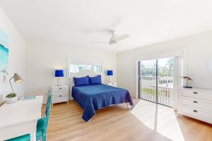 基克罗尼海滩Sea Pointe & Canal-side Charisma的一间卧室设有蓝色的床和一个阳台