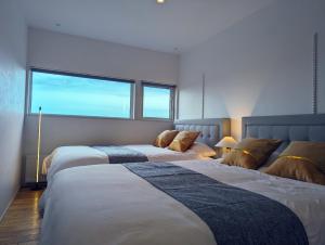 NaganumaOne House Naganuma MAOI - Vacation STAY 09878v的一间卧室设有两张床和大窗户
