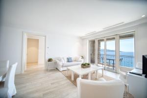 卢什蒂卡Lustica Bay Marina Village by 2BHome的客厅配有白色的沙发和桌子