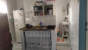 瓜鲁雅Familia Rodrigues的一间带水槽和冰箱的小厨房
