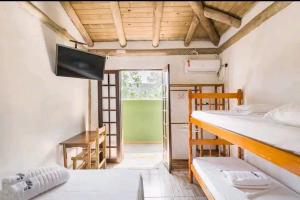乌巴图巴Prumirim Surf Suítes的客房设有两张双层床和一个阳台。