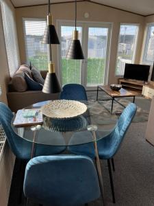 洛西茅斯Playa la Casa的客厅配有桌子和蓝色椅子
