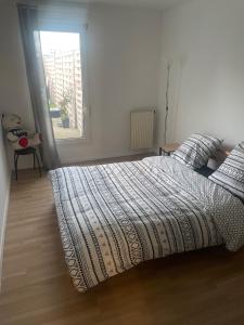 Évry-les-ChâteauxAppartement cosy en plein centre-ville的一间卧室设有一张床和一个窗口