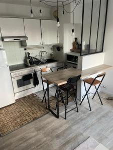 Évry-les-ChâteauxAppartement cosy en plein centre-ville的厨房配有木桌和两把椅子