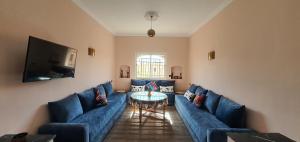 马拉喀什Maison Mamdy的客厅配有蓝色的沙发和桌子