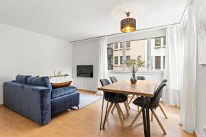 卢塞恩Bright, Central & Modern apartment的客厅配有蓝色的沙发和桌子