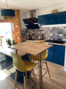 GourbeyreKARUK'IDîLE-Appartement Vue Mer - Plage à 200m的厨房配有木桌和黄色椅子