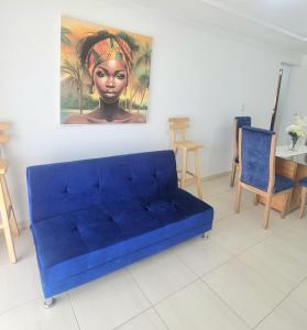 卡塔赫纳Acogedor y Residencial piso 3的客厅里一张蓝色的沙发,上面有绘画作品