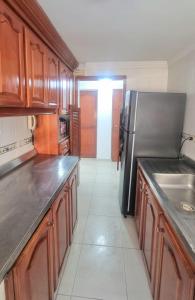 卡塔赫纳Acogedor y Residencial piso 3的厨房配有木制橱柜和不锈钢冰箱。