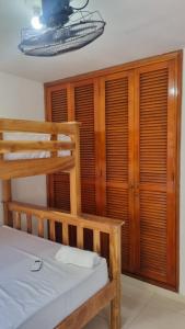 卡塔赫纳Acogedor y Residencial piso 3的卧室配有双层床、木墙和窗户。
