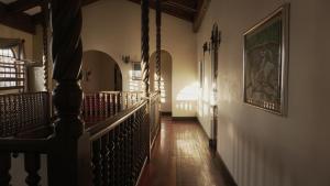 圣何塞卡萨克隆旅馆的走廊上设有楼梯,墙上有绘画作品