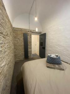 朗塞斯顿Victorian Police Station Apartment的卧室配有砖墙内的床铺