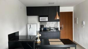 戈亚尼亚Apartamento mobiliado a 500m do Goiânia Shopping的厨房配有黑色橱柜和黑色台面