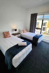帕拉帕拉乌穆U Suites on Trieste Way的配有窗户的酒店客房内的两张床