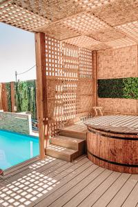 皮卡2 Cabañas para 5 Personas Oasis Pica-Matilla的一个带游泳池和桌子的木制凉亭