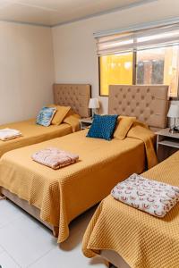 皮卡2 Cabañas para 5 Personas Oasis Pica-Matilla的一间卧室配有两张带橙色床单和蓝色枕头的床。