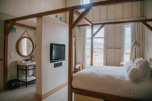 拜圣保罗勒热曼夏荷乐瓦Spa酒店的一间卧室配有一张床、一台电视和一个水槽