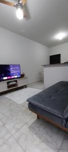 乌贝拉巴Casa próxima ao centro!的客房设有一张床和一台平面电视。