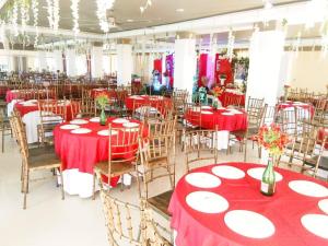 BanguedSorrento hotel resort santa ilocos sur的宴会厅配有红色和白色的桌椅