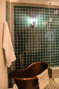特基拉Hotel Boutique Gloriagave的带浴缸的浴室和绿色瓷砖墙