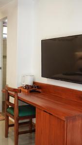 长滩岛Senare Boracay Hotel的一张木桌,墙上有电视