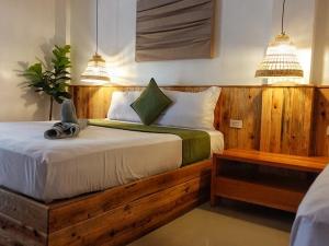 长滩岛Senare Boracay Hotel的一间卧室配有一张带两盏灯的木床。