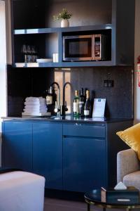 悉尼贝斯沃特精品旅馆 的蓝色的厨房配有水槽和微波炉