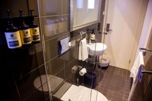 悉尼贝斯沃特精品旅馆 的浴室配有水槽和墙上的一些瓶子