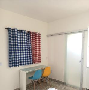 巴西利亚Apartamento Vila Telebrasilia的客房设有两把椅子、一张桌子和一个窗户。