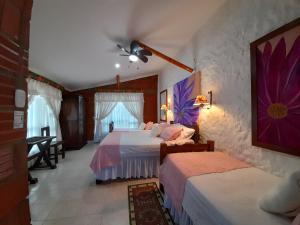 金巴亚Villa Luzandi的一间卧室配有两张床和吊扇
