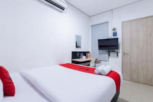 雅加达RedDoorz Plus Syariah near Mall Pondok Indah的白色的客房配有床和电视。