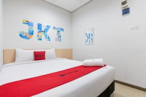 雅加达RedDoorz Plus Syariah near Mall Pondok Indah的一间卧室配有一张床铺,床上铺有红色毯子