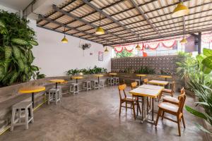 雅加达RedDoorz Plus Syariah near Mall Pondok Indah的一间设有桌椅的餐厅,种植了植物