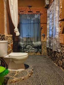 武吉拉旺武吉拉旺朱尼亚旅馆的浴室设有卫生间和带艾菲尔铁塔的浴帘。