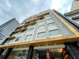 吉隆坡Kingston Hotel Kuala Lumpur的前面有一间商店的高楼