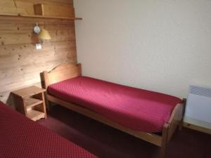 瓦尔莫雷尔Appartement Les Avanchers-Valmorel, 2 pièces, 5 personnes - FR-1-356-356的一间房间,里面设有一张红色的床