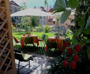 马累Le Colombe的一个带桌椅和遮阳伞的庭院