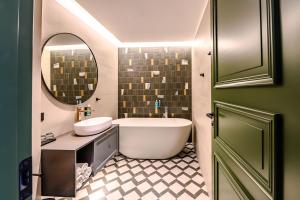 奥泰佩Ugandi Hotel的带浴缸、水槽和镜子的浴室