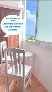 芭东海滩88 House Patong的窗户客房内的白色椅子