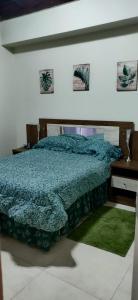 蒙特哥贝Guango Grove Cozy Corner的一间卧室配有一张带蓝色棉被的床和一张书桌