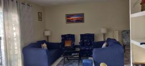 蒙特哥贝Guango Grove Cozy Corner的客厅配有2张蓝色的沙发和1张桌子