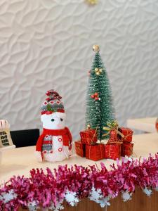 长滩岛BLUE OCEAN BOUTIQUE HOTEL - Boracay Island的圣诞树和一张桌子上的雪人,带礼物