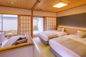 仙台TAOYA Akiu的酒店客房,设有两张床和一张沙发