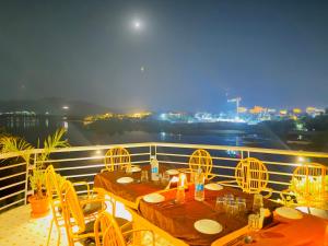 乌代浦Atrangi Hotel & lakeview cafe at PICHOLA LAKE by JD的美景阳台配有2张桌子和椅子